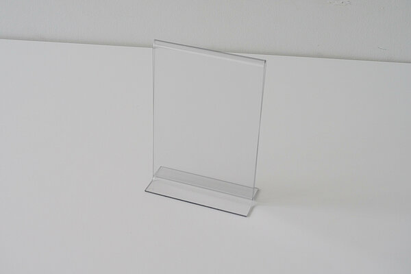Un présentoir de table transparent, au format A6 vertical, vue légèrement de côté