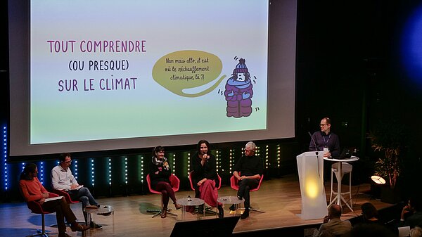 La scène de l'amphi A du pôle événementiel avec trois conférenciers